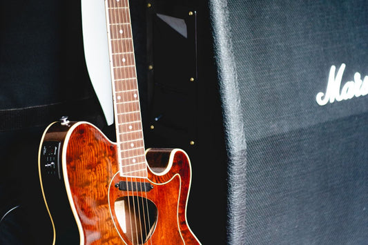 Guitar next to a Marshall amplifier representing the tube vs digital amp debate