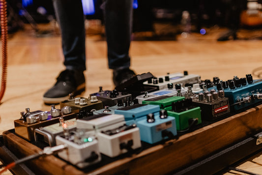 Assorted colorful guitar effects pedals laid out on a surface representing the overwhelming variety of tone options available to modern guitarists