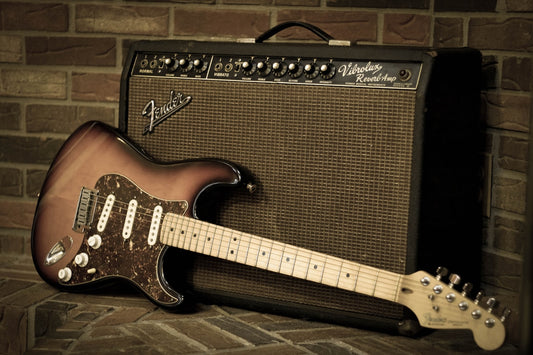 Electric guitar leaning against a vintage amplifier in a studio setting