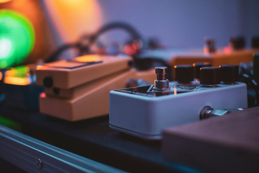 Close-up of guitar effects pedalboard with multiple stompboxes and signal processing units