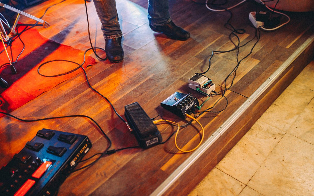 Guitar effects pedalboard on stage with various analog pedals ready to pair with a digital amp modeler