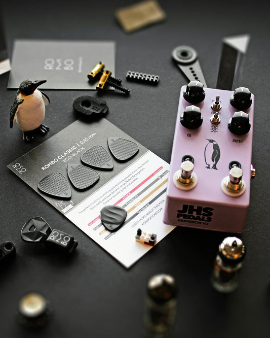 Guitar pedalboard with effects pedals and cables in a studio setup