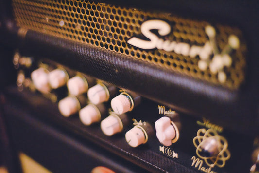 Close-up of a guitar amplifier head with control knobs, representing the analog amps that NAM A2 technology captures digitally