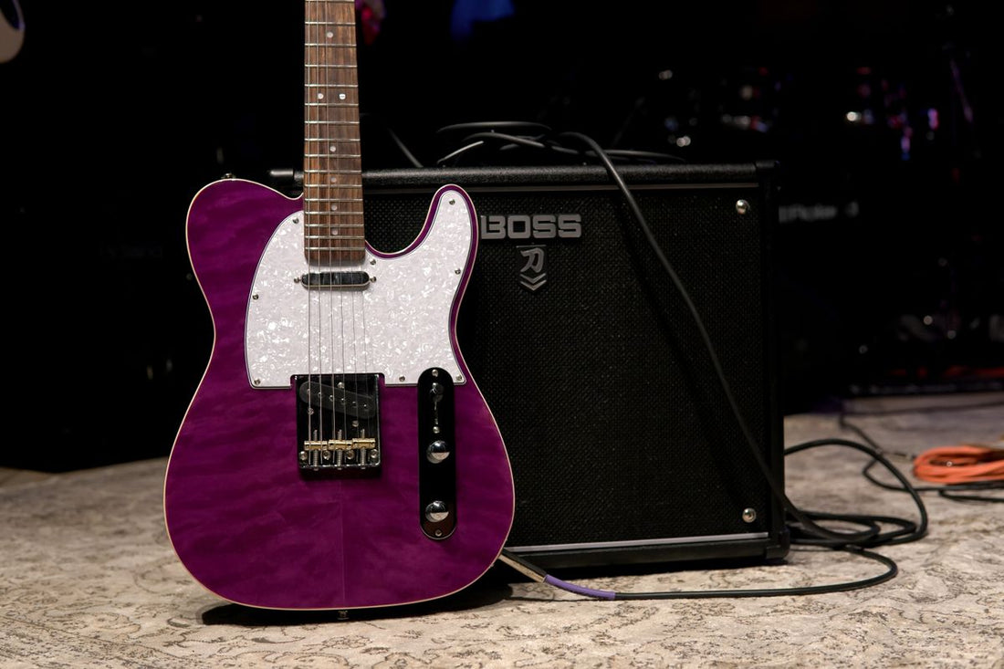 Guitar amplifier on stage with purple lighting, close-up view of amp and electric guitar