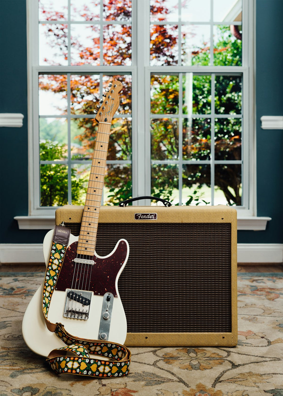 Electric guitar and amplifier in a home studio setup with natural window light