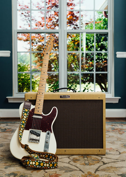 Electric guitar and amplifier in a home studio setup with natural window light