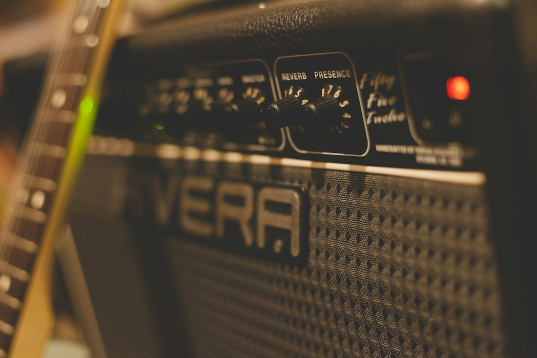 Close-up of a guitar amplifier with glowing tubes and vintage knobs in a studio setting