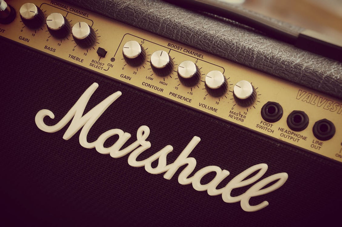 Close-up of a Marshall guitar amplifier with golden control knobs and classic branding